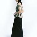 Side view of a woman wearing Werable's sage green off shoulder top with Hakama full length pants in black.
