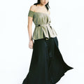 Front view of a woman wearing Werable's sage green off shoulder top with Hakama full length pants in black.