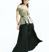 Front view of a woman wearing Werable's sage green off shoulder top with Hakama full length pants in black.