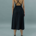 Back view of a woman wearing Werable's black cross back dress.