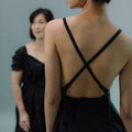 Close-up of a cross-back dress, highlighting the crossed straps on the back.