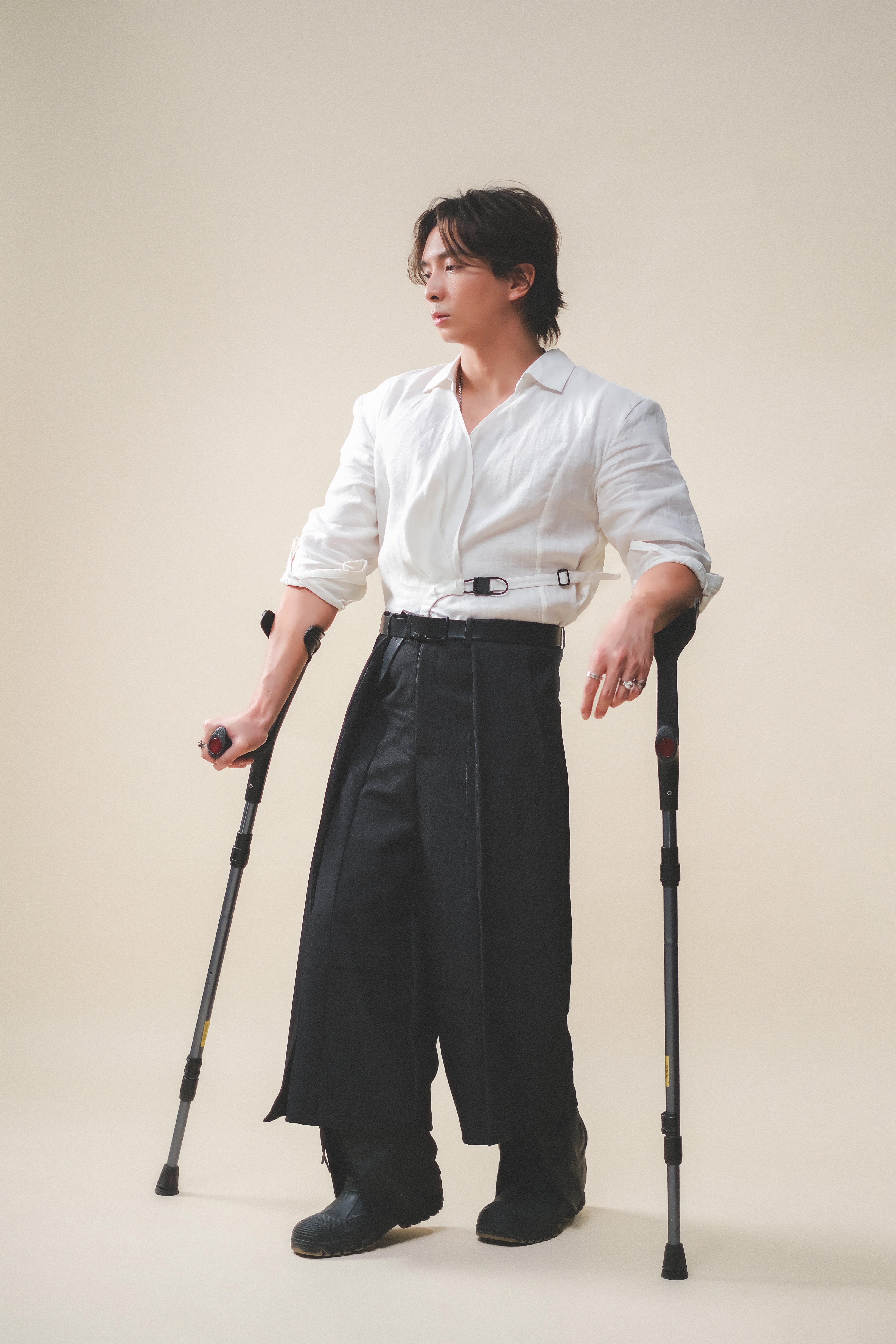 A man standing with crutches,, wearing Werable's easy grip buckle shirt with Hakama culottes. 