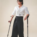 A man standing with crutches,, wearing Werable's easy grip buckle shirt with Hakama culottes. 