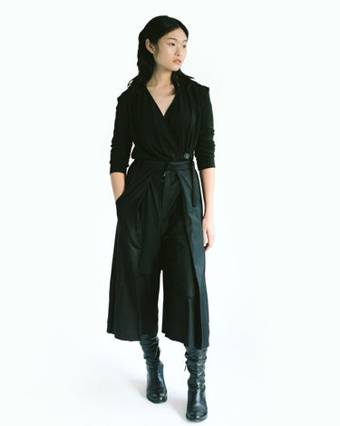 Front view of a woman wearing Werable's easy-grip buckle wrap shirt with hakama culottes in black. 