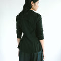 Back view of a woman wearing Werable's easy grip buckle wrap shirt with hakama culottes in black. 