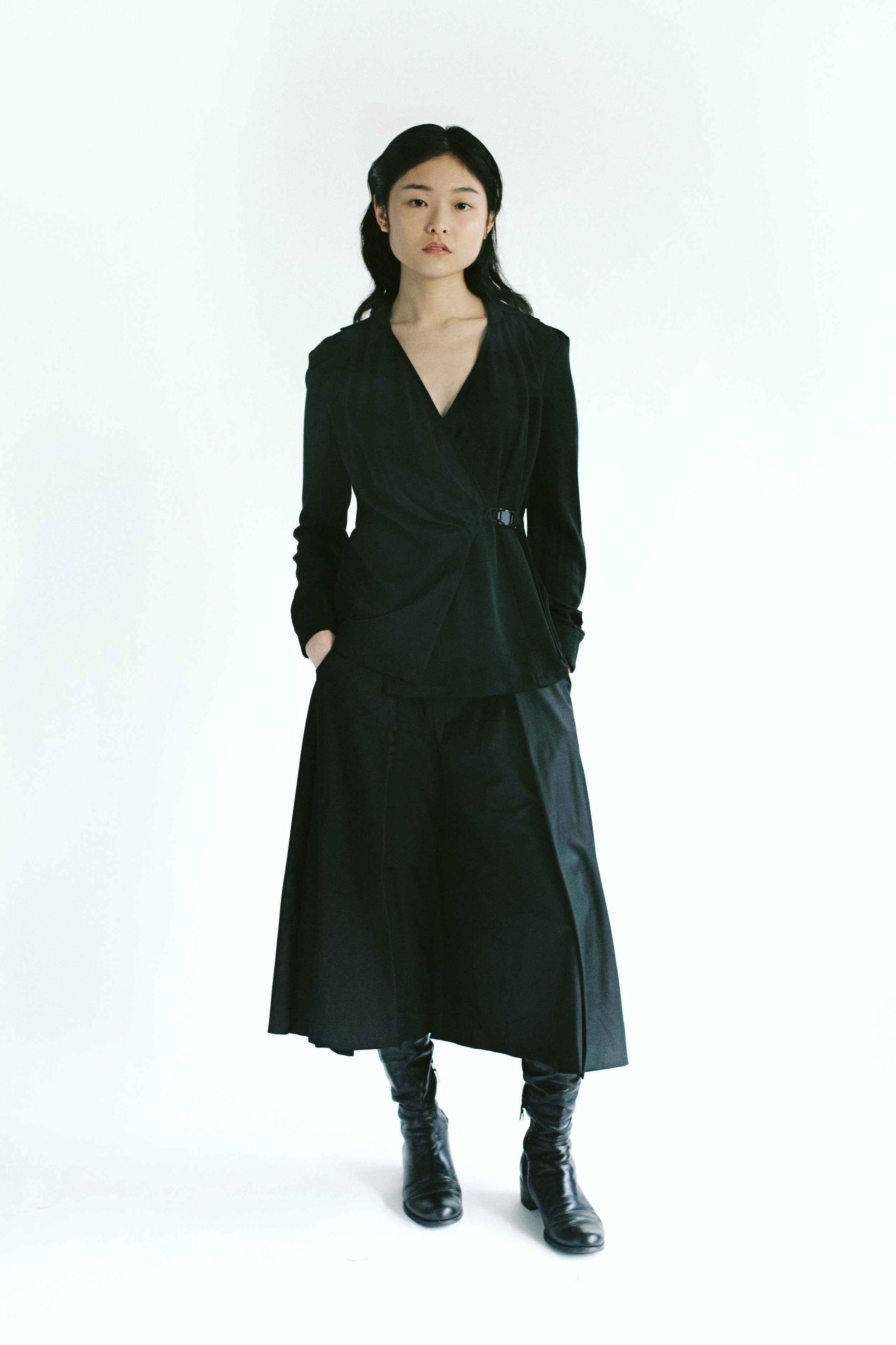 Front view of a woman wearing Werable's easy grip buckle wrap shirt with hakama culottes in black. 